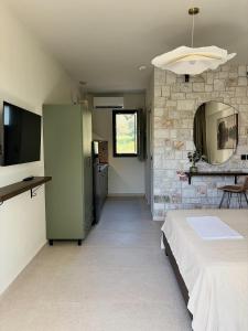 a room with a bed and a stone wall at Noima Kalamitsi Boutique Studios in Kalamitsi
