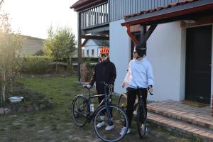 a man and a woman standing next to a bike at Smugi Dom Gościnny in Lipowiec