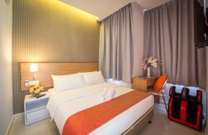 a hotel room with a large bed and a chair at Sovotel Uptown 101 in Petaling Jaya