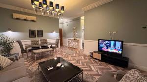 a living room with a couch and a television at Dream Royal Residence in 6th Of October