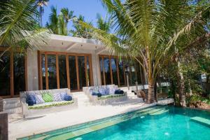 a house with a swimming pool and palm trees at RiverView Gardens in Ubud