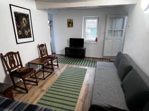 a living room with a couch and chairs and a tv at Casa Albastra in Mahmudia