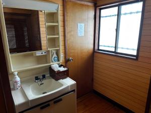 a bathroom with a sink and a mirror and a window at Aburatsu Inn Kadocco in Nichinan +41 photos