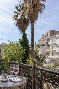a table with wine glasses on a balcony with palm trees at Once&Forever Estate in Athens