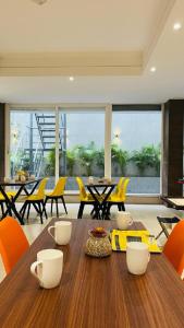 a dining room with a wooden table and yellow chairs at ZEN Studios - DLF CyberCity Gurgaon in Gurgaon