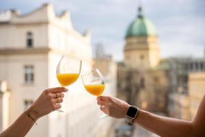 two people holding up glasses of wine at Super Central Modern Studio #Palace View #55''Smart TV #Fast Wi-Fi #Metro in Warsaw