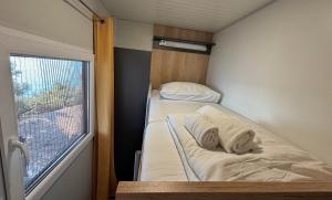 a small room with two beds and a window at Hipo camp - Mobil home Sestrica in Pakoštane