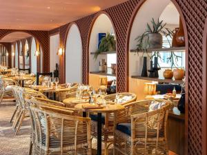 ein Esszimmer mit Holztischen und Stühlen in der Unterkunft Novotel Luxembourg Kirchberg in Luxemburg (Stadt)