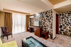 a hotel room with a stone wall at Borjomi Palace Health & Spa Center in Borjomi