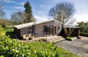 a small wooden cabin with two chairs in a yard at Eeyore's Place in Hythe