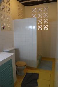 a bathroom with a toilet and a bath tub at Villa Madinina in Diani Beach +28 photos