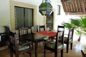 a dining room with a table and chairs at Villa Madinina in Diani Beach