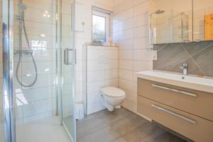 a bathroom with a toilet and a sink and a shower at FerienGut Gaarz - Im Park 3 in Göhl +23 photos