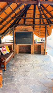a large stone patio with a large fireplace in a wooden roof at Pangolin self-catering accommodation in Windhoek
