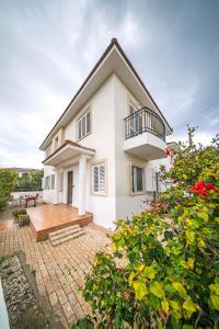 a white house with a balcony and a patio at Villa Stella with Jacuzzi in Oroklini