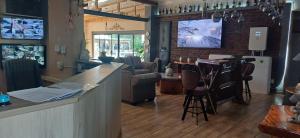 a bar in a restaurant with a counter and chairs at Potties Guesthouse in De Aar