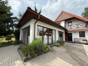 a house with a bench in front of it at Borki Guest House in Smardzewice