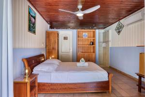 a bedroom with a bed and a ceiling fan at L'Escale Royale in Salazie