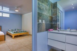a bathroom with a sink and a bed in a room at L'Escale Royale in Salazie +14 photos