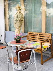 a patio with a table and a chair and a table with a statue at Buddha-Loft in Solothurn