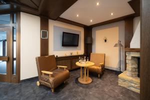 a room with two chairs and a table and a tv at Hotel Baeren in Leimen