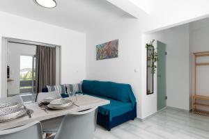 a living room with a blue couch and a table at House of Helios in Pastida