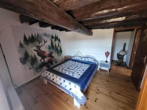a bedroom with a bed with a deer mural on the wall at Maison ferme équestre du Ténéré in Saint-Jean-Lachalm