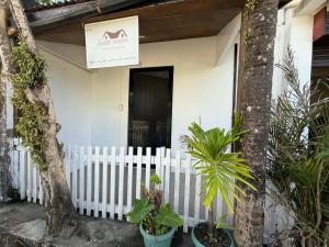a white house with a white fence and plants at Pinkys Guest House in Allen