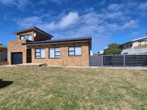 a brick house with a large yard at Hello Home Struisbaai in Struisbaai