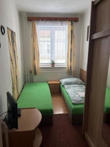 a small room with two beds and a window at Apartmány v centru in Havlíčkŭv Brod