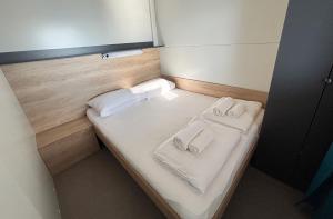 a small bed with two towels and two towels at Hipo camp Mobil home Arta in Pakoštane +36 photos