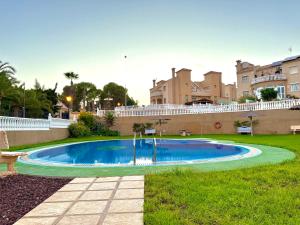 a swimming pool in the grass in front of a building at Mar y Golf in Orihuela Costa