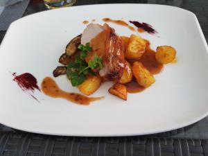 a plate of food with potatoes and meat at Pension Tannenhof in Laces +7 photos