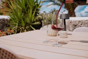 a person pouring wine into two wine glasses on a table at Finca Thiago in Puerto Calero