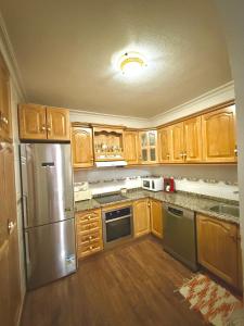 a kitchen with wooden cabinets and a stainless steel refrigerator at Mar y Golf in Orihuela Costa