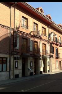un gran edificio de ladrillo con balcones en una calle de la ciudad en Hospederia Fernando I, en León