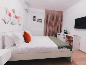 a bedroom with a bed and a desk and a television at La tana del Furlo in Acqualagna