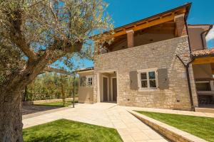 a brick house with a tree in front of it at Villa Natalie in Vabriga