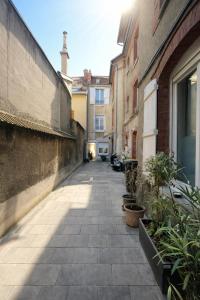 an alley with buildings and plants on the side at Nuit D'or - Chardonnay - Séjour & Pro in Épernay