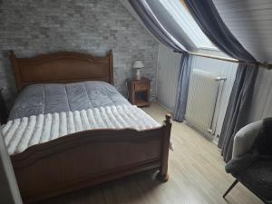 a bedroom with a large bed and a window at Jardin Floral in Marquise