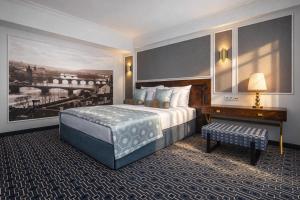 a hotel room with a large bed and a desk at Grand Hotel International - Czech Leading Hotels in Prague