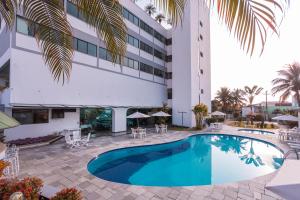 a swimming pool in front of a hotel at Hotel Aojesp in Caraguatatuba