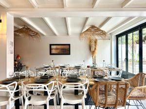 a dining room with a large wooden table and chairs at Hôtel Ancre Marine & Spa Thalgo *** in Noirmoutier-en-l'lle