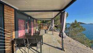 a patio with chairs and a table and an umbrella at Hipo camp Mobil home Arta in Pakoštane