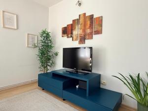 a living room with a tv on a blue cabinet at Moon Stylish -FREE parking -Romantic City Stay in Timişoara