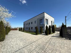 a large white building with a brick driveway at Silver Residence Caracal in Caracal