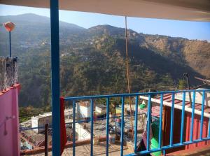 a balcony with a view of a mountain at The Devine homestay in Ukhimath