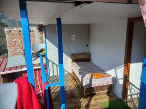 a small room with a bed and a balcony at The Devine homestay in Ukhimath