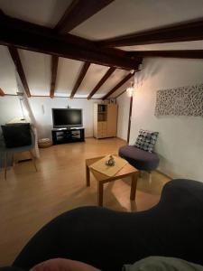 ein Wohnzimmer mit einem Tisch und einem Fernseher in der Unterkunft Casa Foresta in Maggia