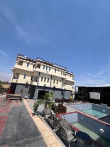 a hotel with a swimming pool and a building at Enseno Hotel in Karshi